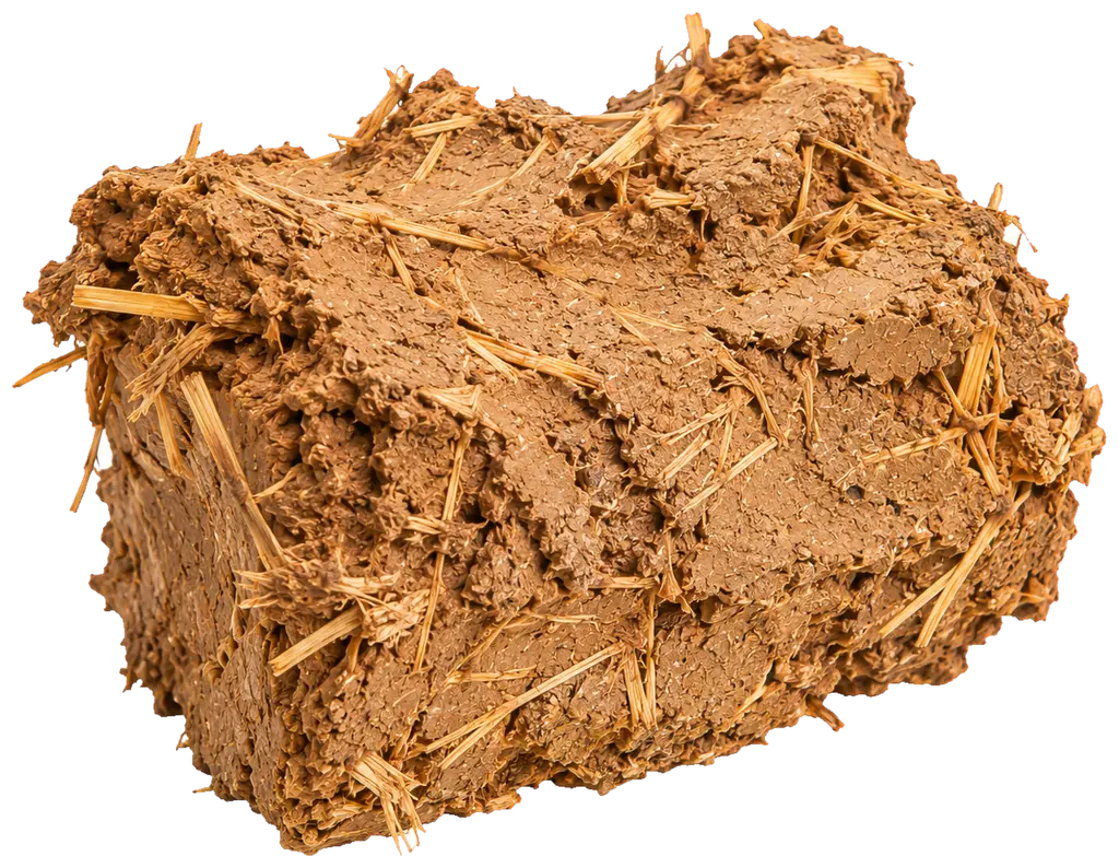 Une masse de terre brune compacte, sans arête ni forme régulière : elle a été empilée et pressée à la main, pas moulée. La paille y est bien plus présente que dans une brique d'adobe, en touffes longues qui dépassent de partout et nouent la masse. La surface porte les traces du geste.