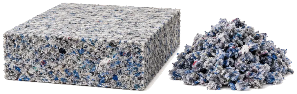 Un panneau isolant en fibres textiles recyclées, tranche coupée face à l'objectif : le mouchetis de fibres bleues, grises et blanches trahit son origine, du vêtement collecté et défibré. À droite, les mêmes fibres en flocons, pour le soufflage en combles perdus. λ de l'ordre de 0,039 dans les trois formes.